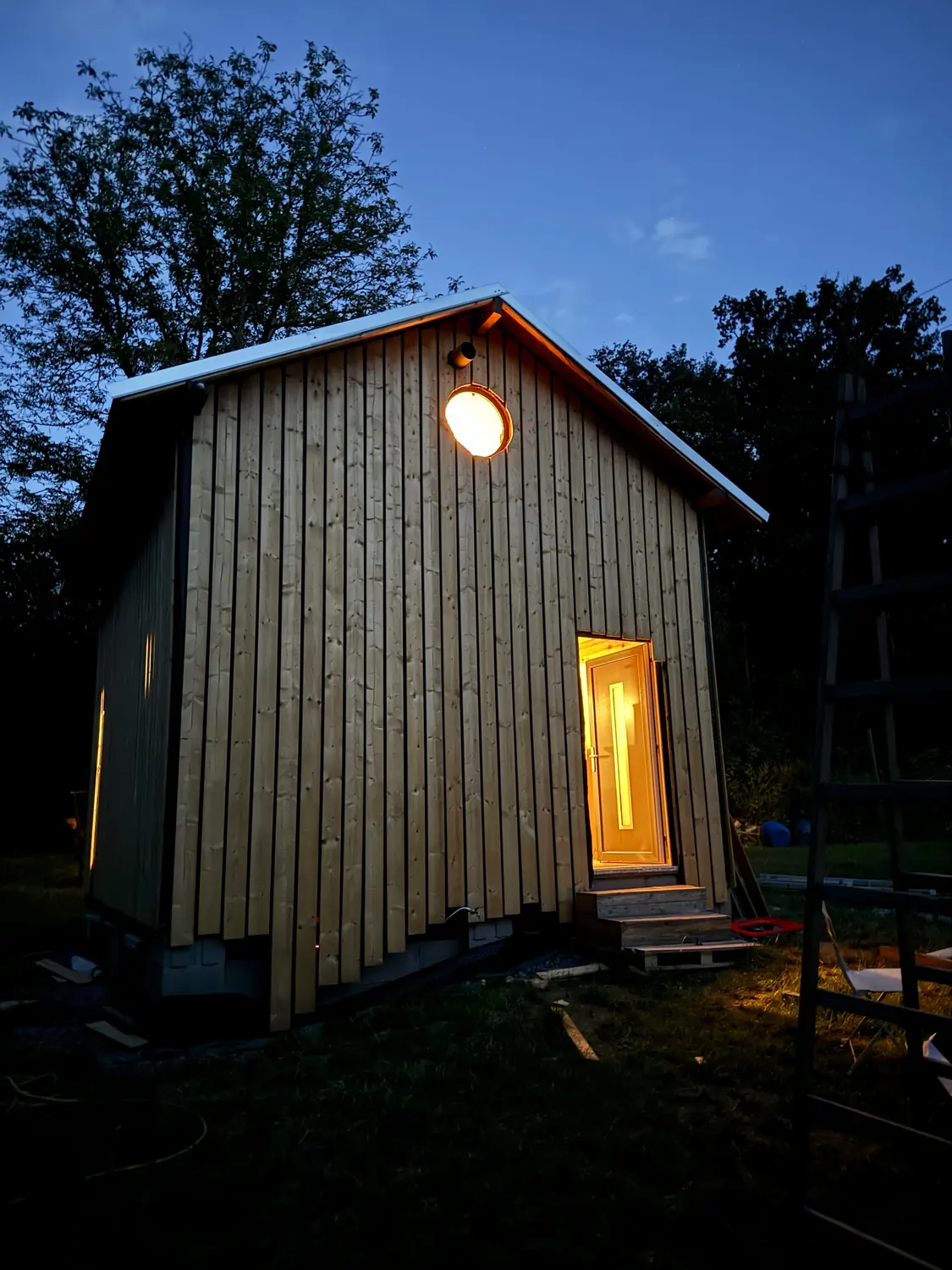 Dřevěný dům večer s rozsvíceným oknem